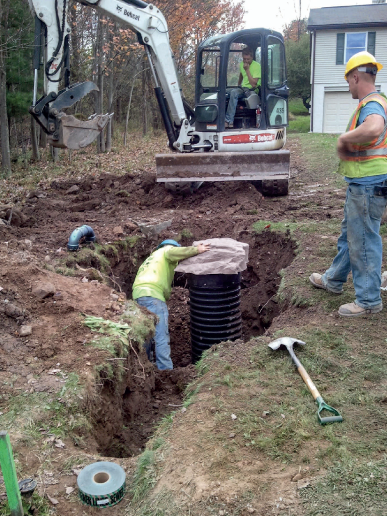 Three men installing a pressure sewer system
